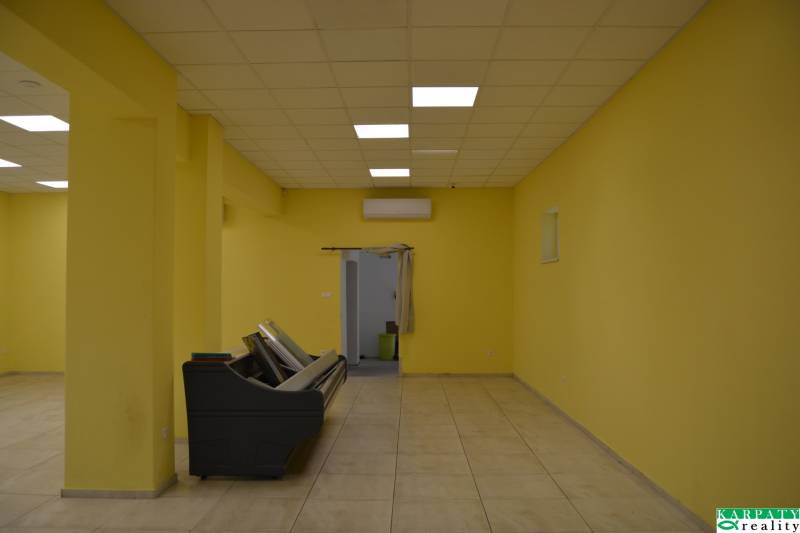 Sárga falak, csempe és mennyezeti világítás az üzlethelyiségben.