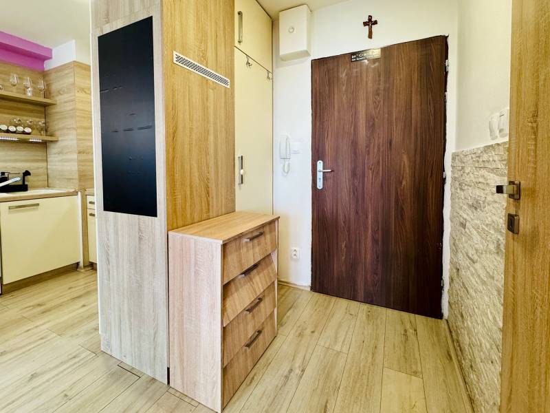 2 szobás lakás előtere fa padlóval és konyhasarokkal.