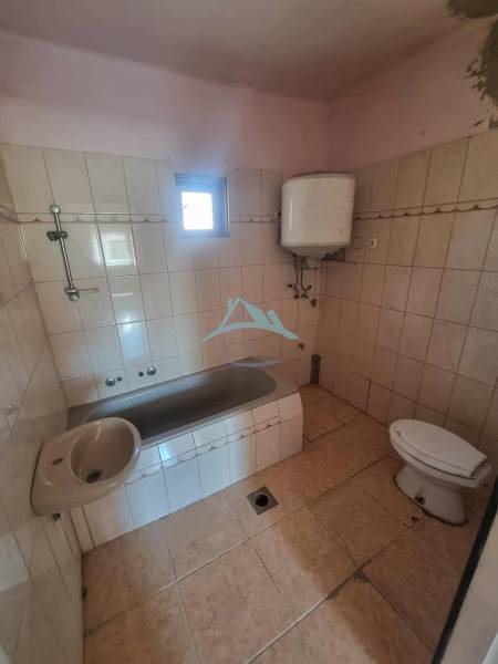Fürdőszoba családi házban káddal, mosdóval, WC-vel és bojlerrel.