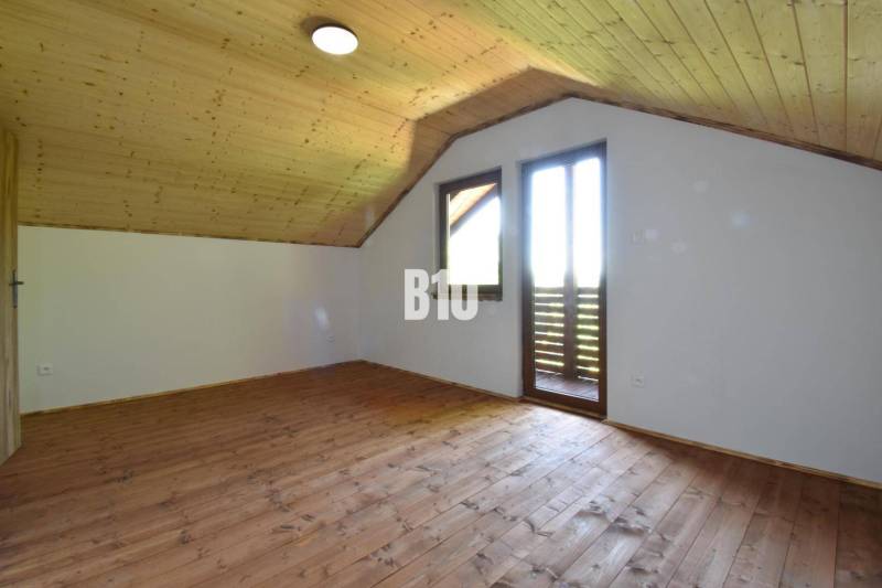 Tetőtéri szoba fa burkolattal és padlóval a Bytča melletti házban.