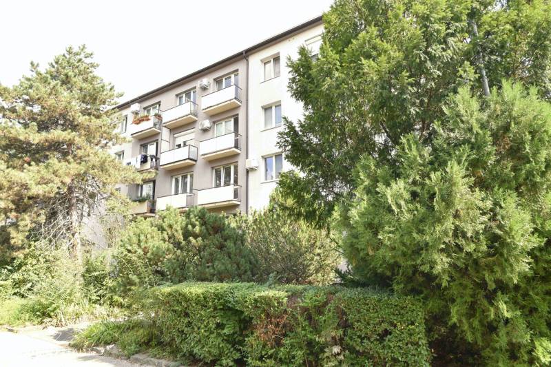 Zölddel körülvett lakóház a Pozsony-Ružinov Smolnícka utcában, erkélyekkel.