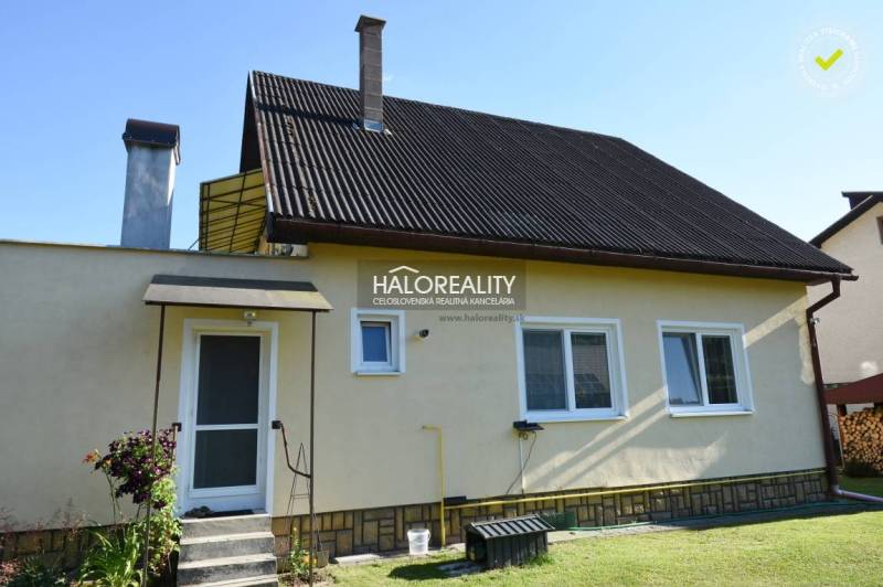 Családi ház Zsúpkón fém tetővel, kerttel és két kéménnyel.