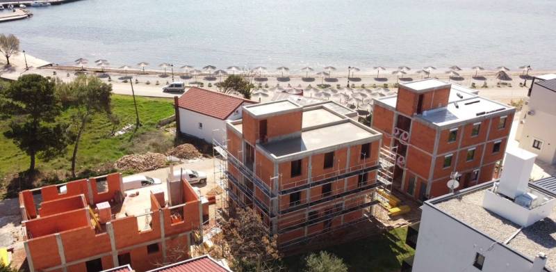 Építkezési munkák a Vir városában található strandon, félkész épületekkel a part közelében.