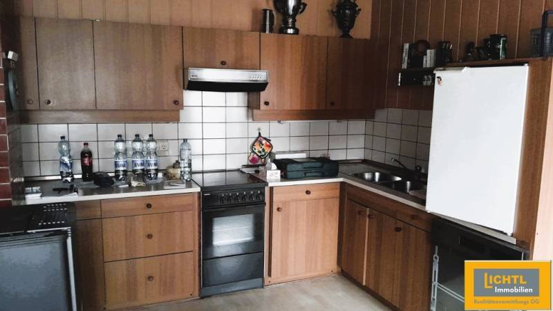 Konyha családi házban fa szekrényekkel és fehér csempékkel.