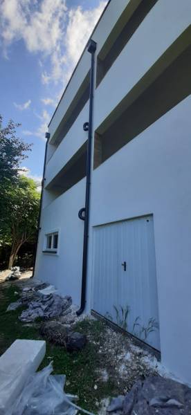 Villa fehér homlokzattal és ferde gyepfelülettel a bejáratnál Hainburg an der Donau-ban.