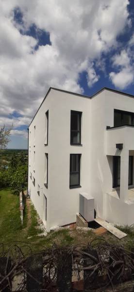 Fehér homlokzatú villa Hainburg an der Donau-ban, modern fekete ablakokkal.