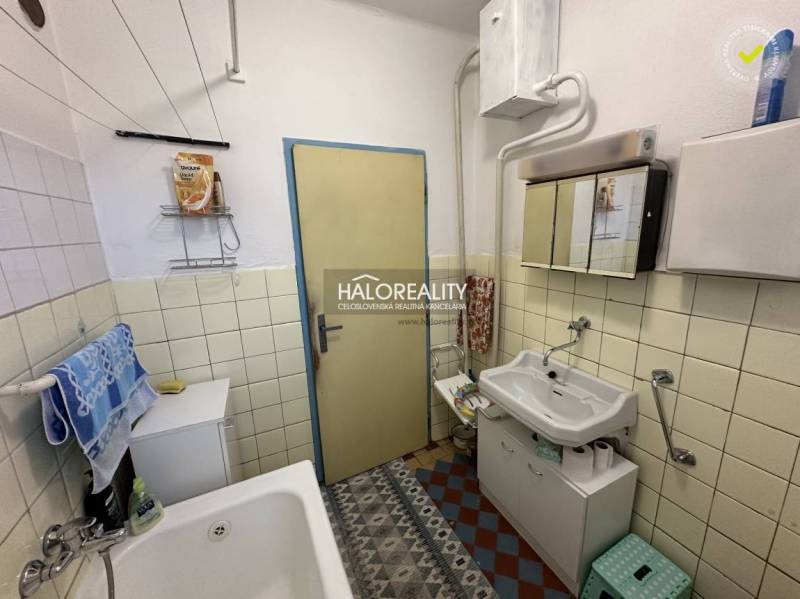 Fürdőszoba családi házban mosdóval, káddal és tárolóhellyel.