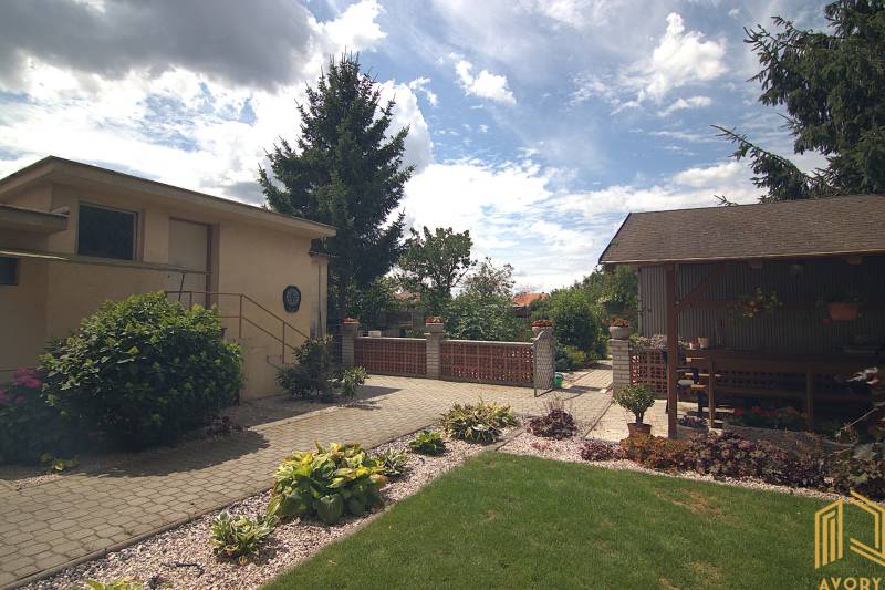 Családi ház a Brodsko-i Športová utcában, kert pavilonnal és rendezett gyep.