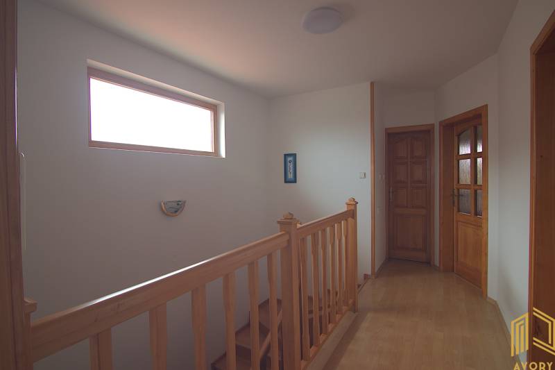 Fa lépcső ablakokkal és ajtókkal egy családi házban, belső tér.