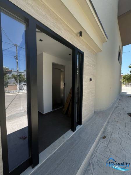 A Ksamilban található rekreációs apartman bejárata üvegajtóval és világos belső térrel rendelkezik.