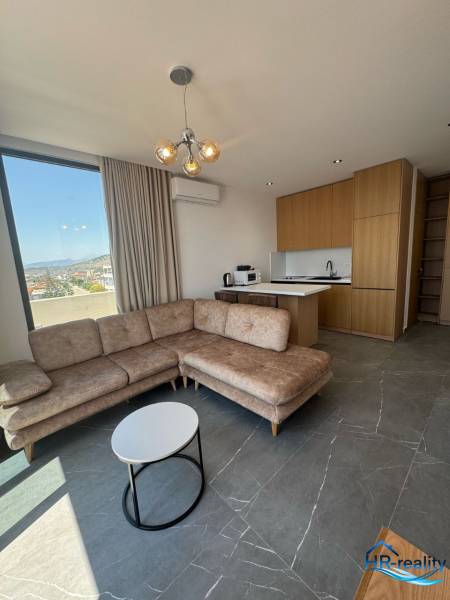 Nyaraló apartman nappalija sarokkanapéval, kilátással és konyhasarokkal.