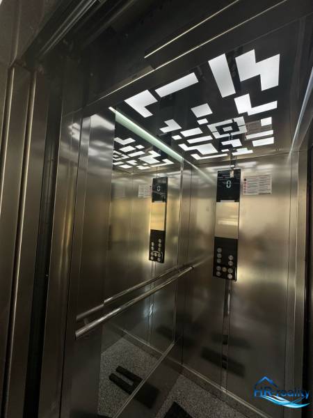 A modern világítással és tükrökkel ellátott lift belseje a Rekreációs apartmanban.