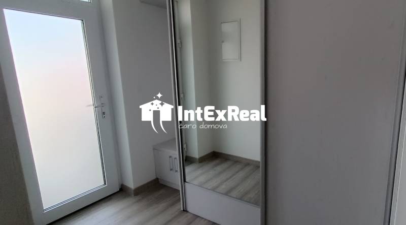 A fehér ajtókkal és beépített szekrénnyel rendelkező 2 szobás lakás előszobája.