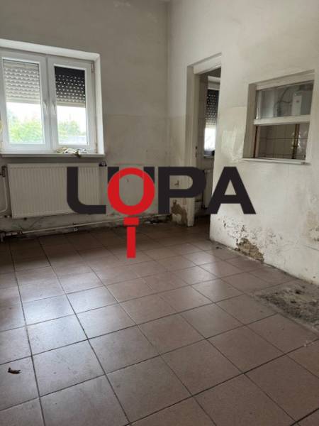 Üres üzlethelyiség ablakkal és radiátorral.