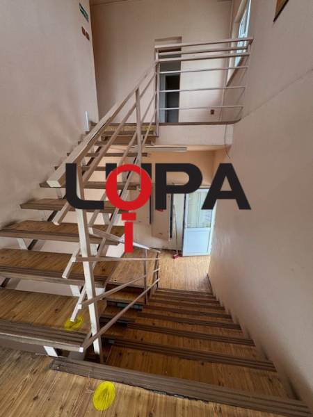 Lépcsőház az épületben fa padlóval és fém korláttal.