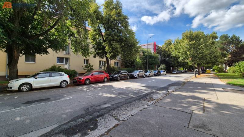 Pod Párovcami utca Pöstyénben, ahol autók parkolnak egy 3 szobás lakás előtt a fák árnyékában.