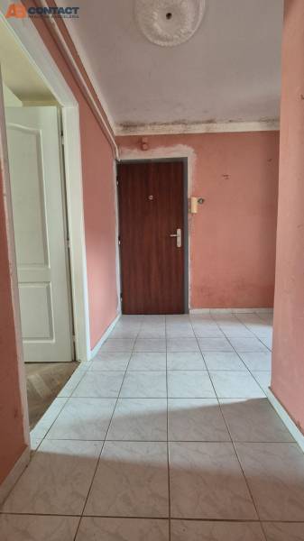 Bejárati folyosó világos csempével és rózsaszín falakkal egy háromszobás lakásban.