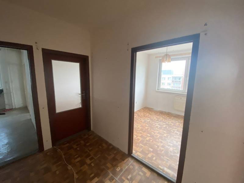 Folyosó egy 3 szobás lakásban faajtókkal és padlóval.