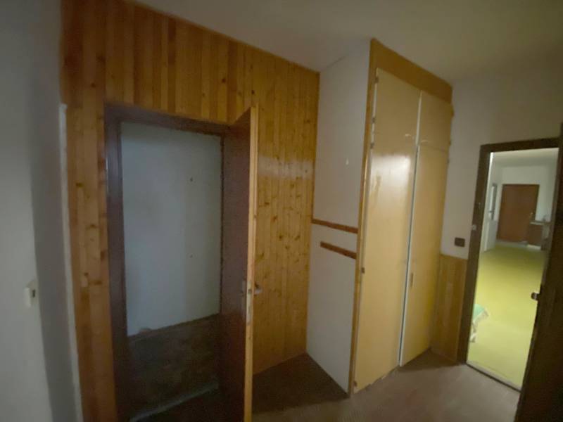 Folyosó fa burkolattal és beépített szekrénnyel egy háromszobás lakásban.