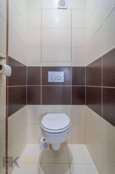 WC barna-fehér csempékkel egy háromszobás lakásban.