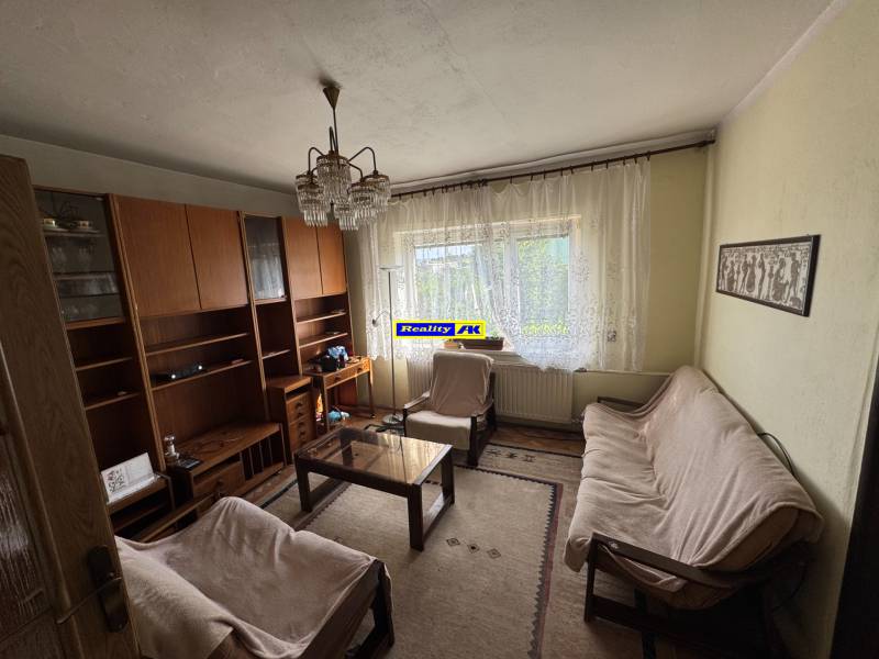 Nappali egy családi házban kanapéval, szőnyeggel, szekrénysorral.
