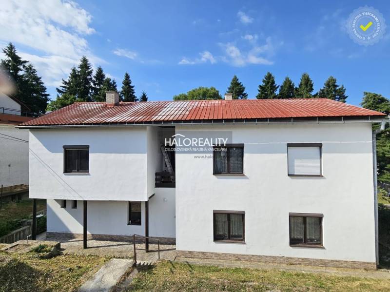 Családi ház piros tetővel és fehér homlokzattal Selmecbányán.