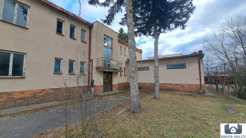 Kétszintes épület fák között a Fő utcán Alsósztregován. Szállodák és panziók.