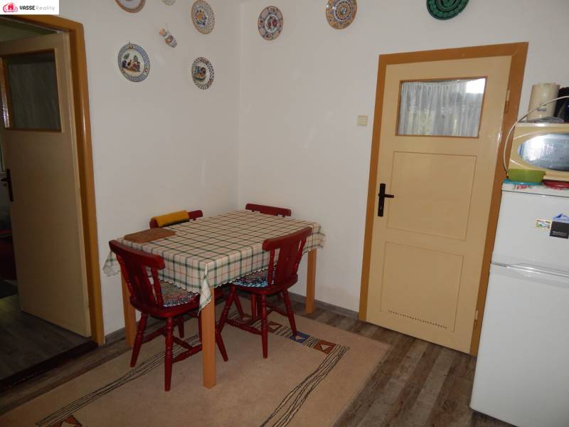 Ebédlő egy faháznál, faasztallal és kerek dekorációkkal a falon.