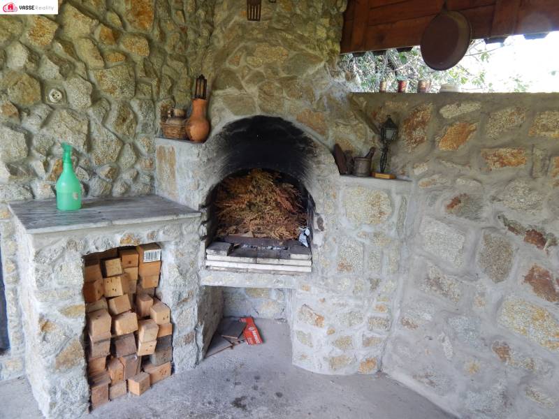 Kő kandalló a házikóban, kőfülkében tárolt fával.