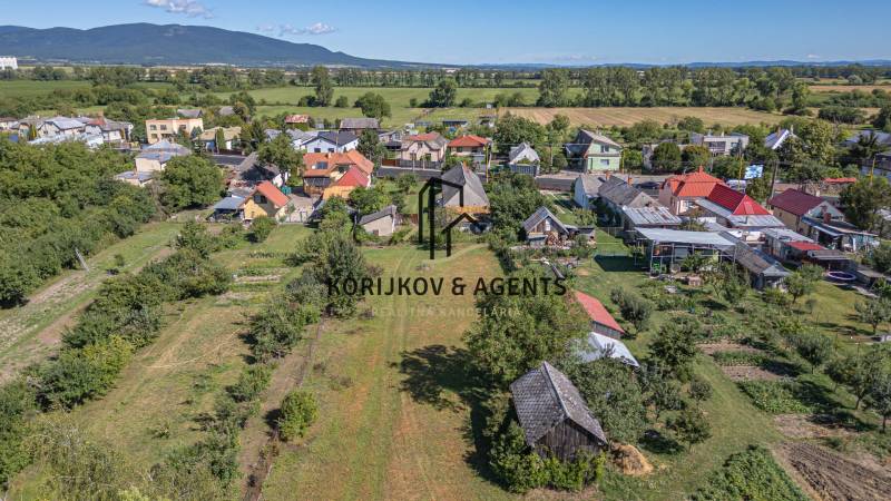 Légi felvétel a Sečovce-i lakóterületekről, amelyeket zöldterületek és házak vesznek körül.