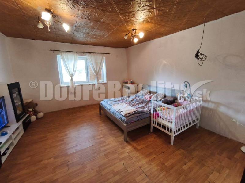 Hálószoba családi házban ággyal, gyerekággyal és fa padlóval.