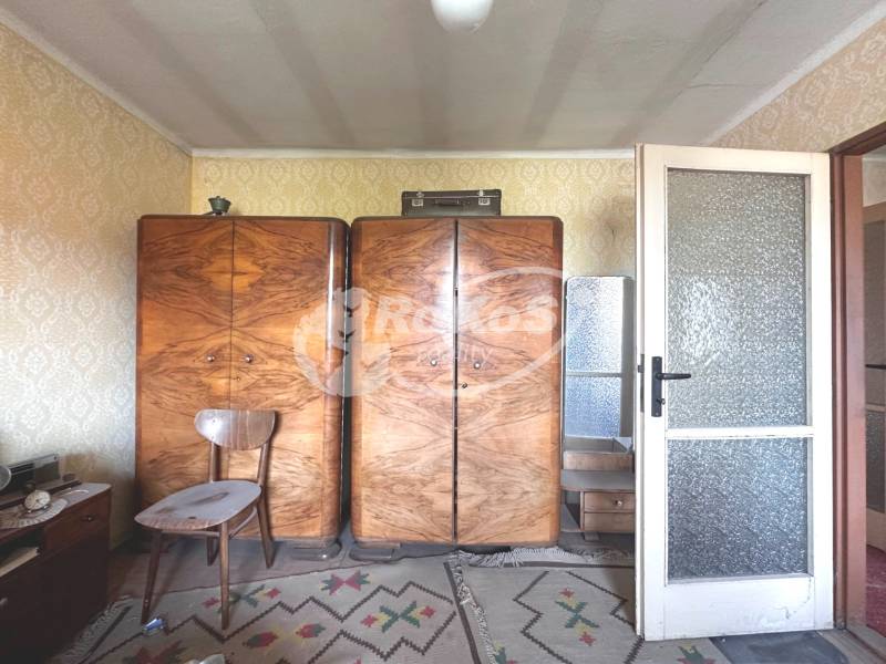 Retro bútor háromszobás lakásban fa szekrényekkel, szőnyeggel és tapétákkal.