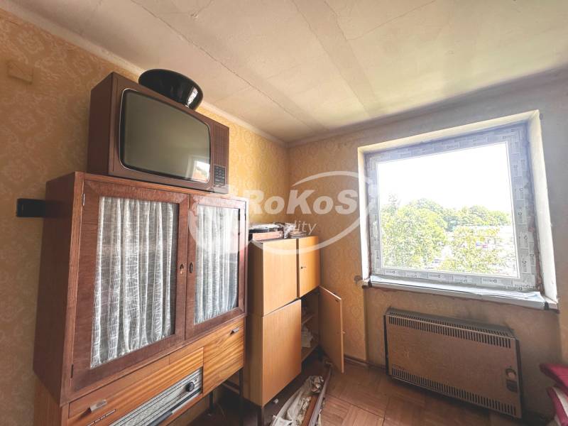 Retró bútorok és televízió egy háromszobás lakásban, kilátással az ablakon keresztül.