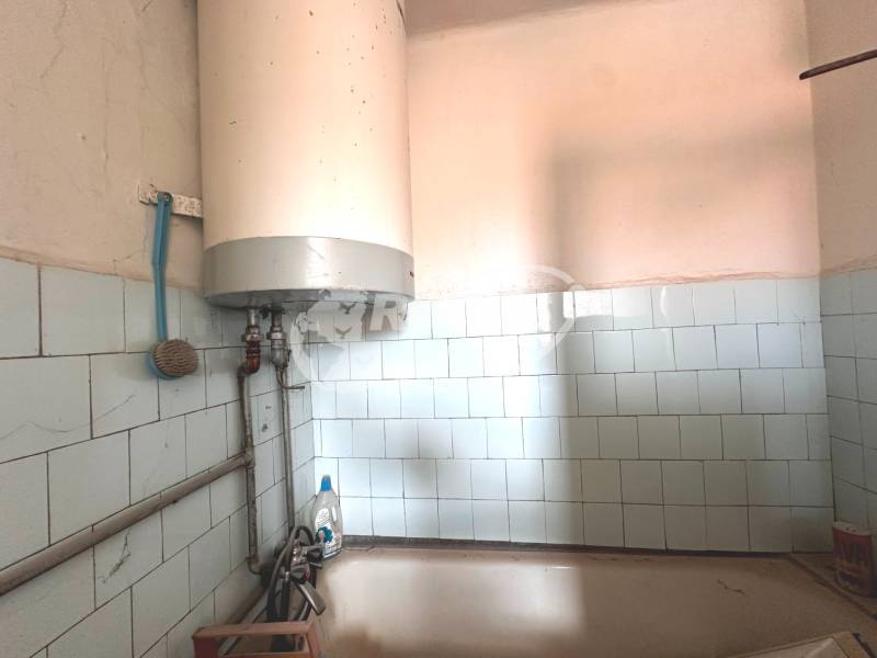 Fali bojler fehér csempékkel egy háromszobás lakás fürdőszobájában.