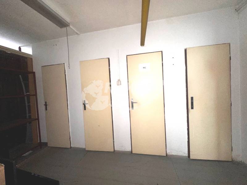 Üzlethelyiség belső tér négy ajtóval és egy polccal.