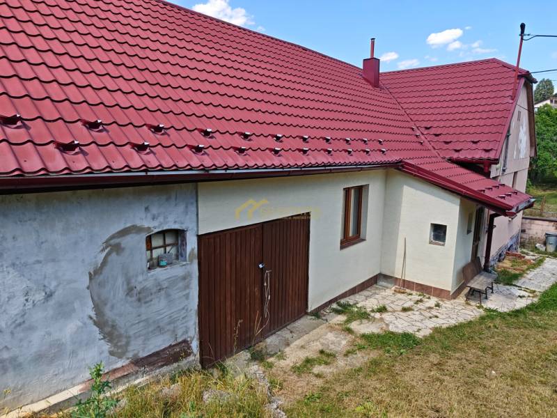 Családi ház a Vranov nad Topľou Dlhá utcáján, piros tetővel és garázskapukkal.