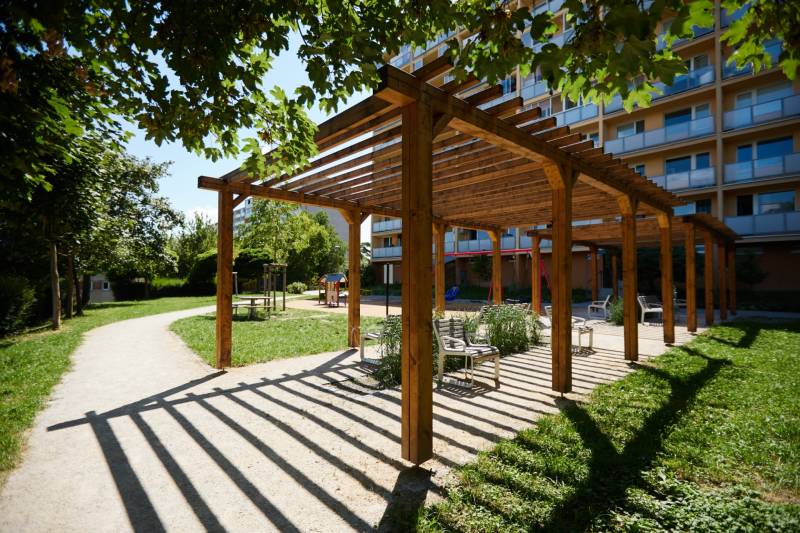 Fából készült pergola padokkal a kassai parkban, Juh városrész, zölddel körülvéve.