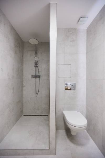 Fürdőszoba zuhanyzóval és WC-vel, minimalista stílusú, kétszobás lakásban.