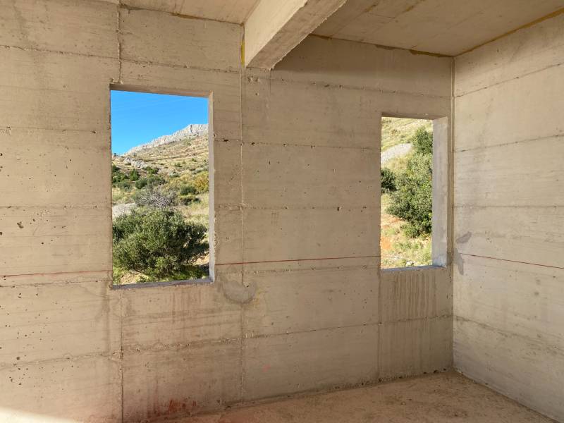 Betonfalak kilátással a természetre a villa belsejében.