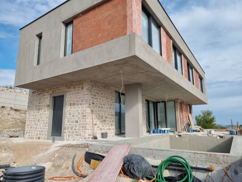 Folyamatban lévő villa Vodicében beton- és téglahomlokzattal, medencével és verandával.