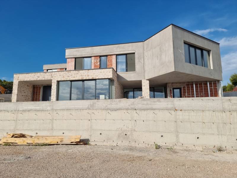 Egy villa külseje Vodice-ben modern ablakokkal és nyers betonnal.