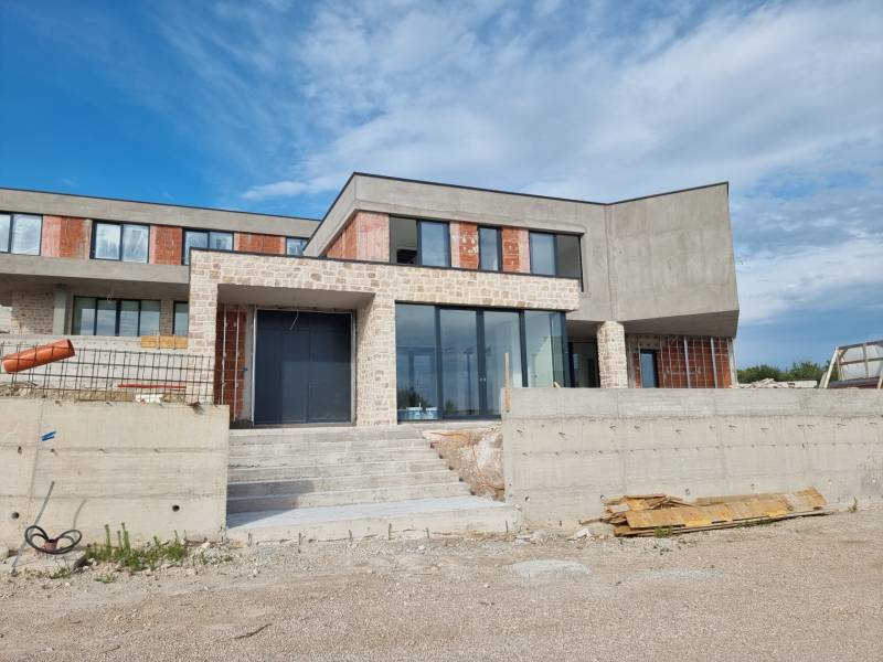 Befejezetlen villa Vodicében nagy üvegfelületekkel és kőburkolattal.