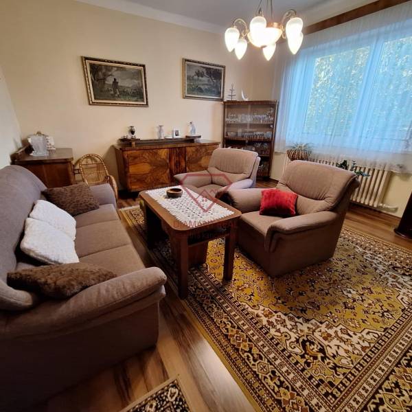 Nappali egy családi házban kényelmes bútorokkal és keleti szőnyeggel.
