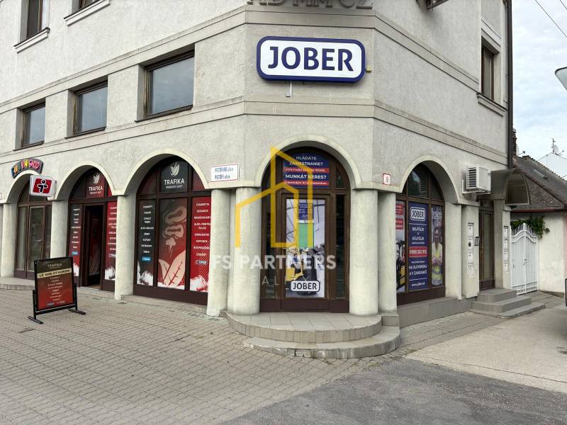 Komárom, Petőfi utca, üzlethelyiségek reklámtáblákkal és több bejárattal.