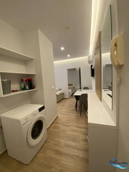 Praktikus elrendezés mosógéppel és étkezőasztallal a nyaraló apartmanban.