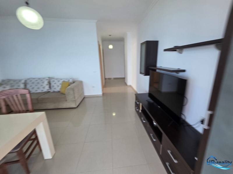 Nappali kanapéval, televízióval és étkezőasztallal a Nyaraló apartmanban.