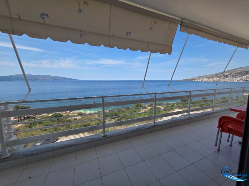 A sarandëi nyaraló apartman erkélye, kilátással a tengerre és a környező tájra.