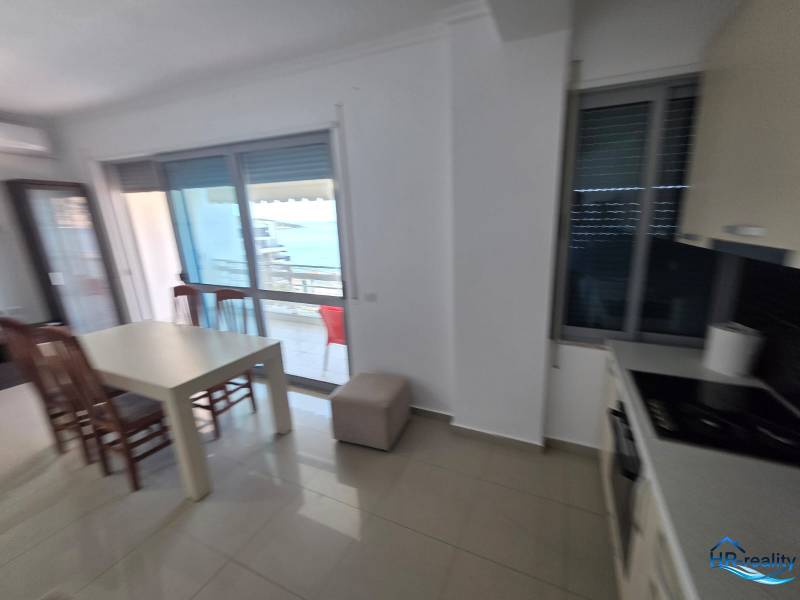 Étkező sarok tengerre néző kilátással egy nyaraló apartmanban, világos belső berendezéssel.