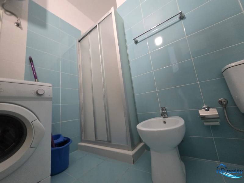 Fürdőszoba a nyaraló apartmanban mosógéppel, zuhanyzóval és bidével.