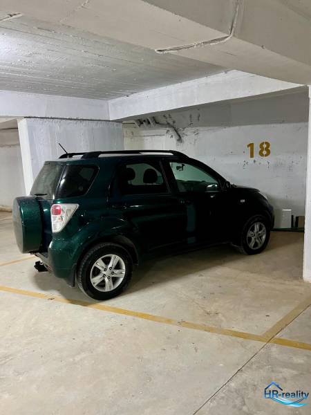 Az autó a garázsban a 18-as parkolóhelyen van leparkolva.